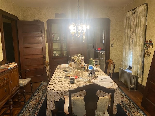 dining room featuring wallpapered walls, a notable chandelier, radiator, and dark wood-style floors