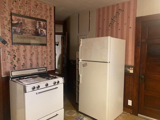 kitchen featuring wallpapered walls and white appliances