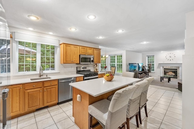 21 Butterfield Ln, Westford, MA 01886 - kitchen featuring appliances with stainless steel finishes, a sink, light tile patterned flooring, light countertops, and a kitchen breakfast bar