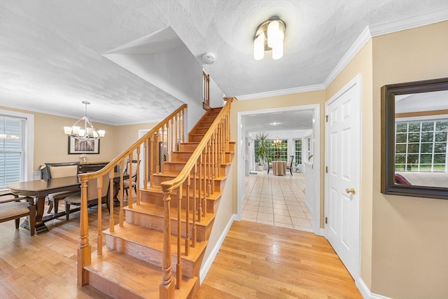 21 Butterfield Ln, Westford, MA 01886 - stairway featuring plenty of natural light, ornamental molding, wood finished floors, a chandelier, and baseboards