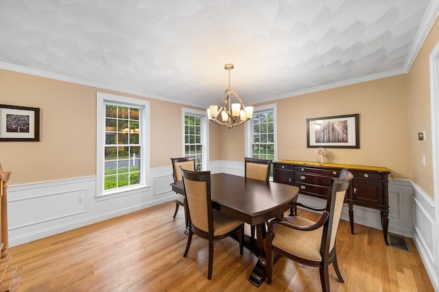 21 Butterfield Ln, Westford, MA 01886 - dining area with a chandelier, light wood finished floors, a wainscoted wall, and crown molding
