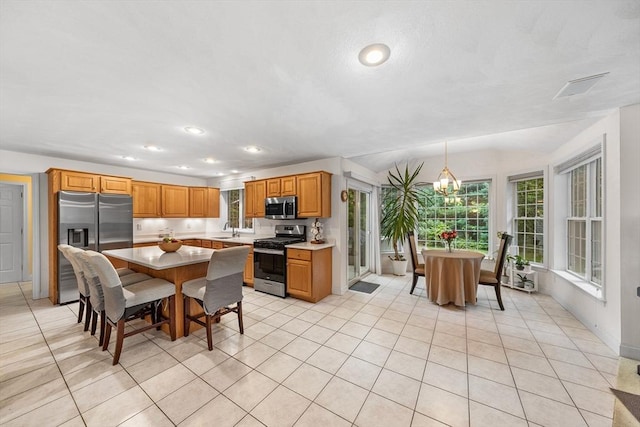 21 Butterfield Ln, Westford, MA 01886 - kitchen featuring appliances with stainless steel finishes, a sink, a kitchen island, light countertops, and light tile patterned floors