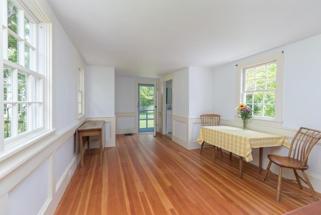 40 Scotchmans Ln, West Tisbury, MA 02575 - dining area featuring light wood-style flooring, a wainscoted wall, and a decorative wall