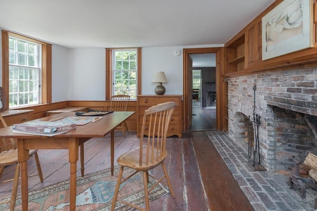 40 Scotchmans Ln, West Tisbury, MA 02575 - dining space with a brick fireplace, a wainscoted wall, and wood finished floors