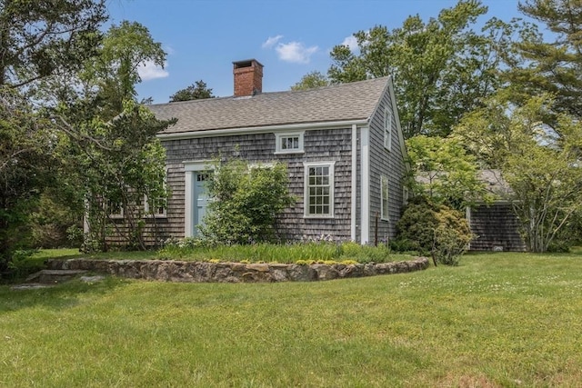40 Scotchmans Ln, West Tisbury, MA 02575 - view of home's exterior featuring a chimney, a yard, and a shingled roof