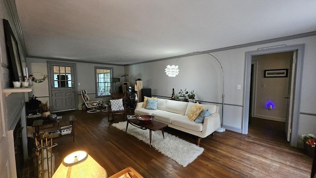 living area featuring ornamental molding, wood finished floors, and baseboards