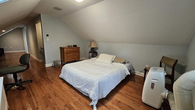 bedroom featuring wood finished floors, vaulted ceiling, and baseboards