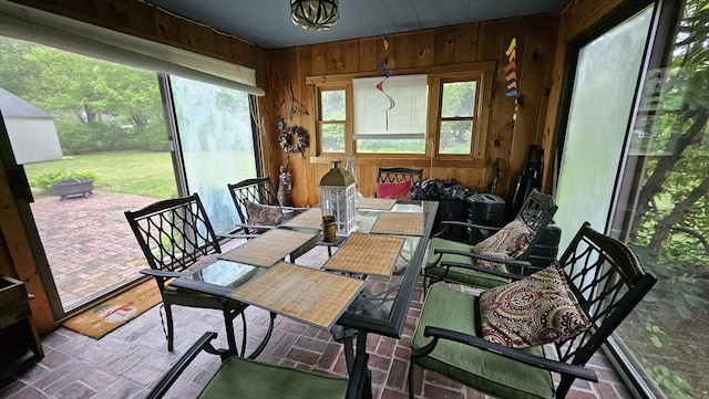 sunroom with brick patterned flooring and wooden walls