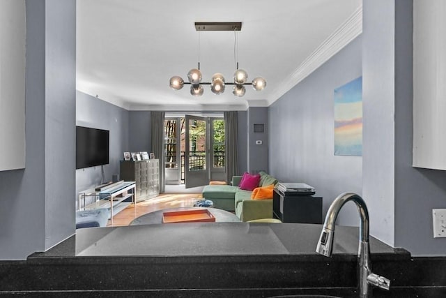 living area with ornamental molding and a chandelier