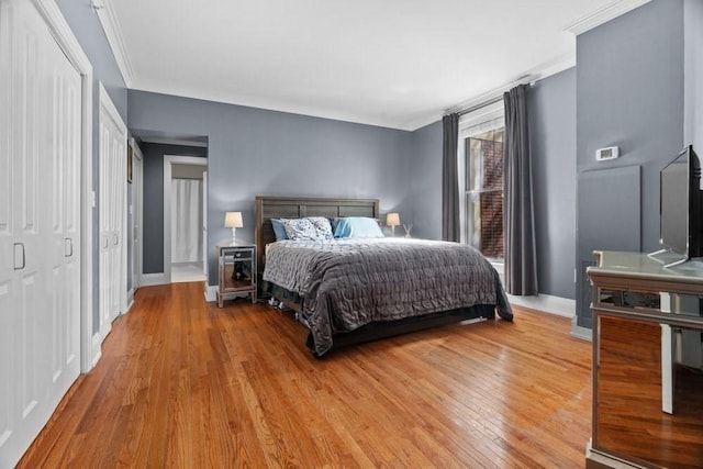 bedroom featuring baseboards, ornamental molding, and light wood-style flooring