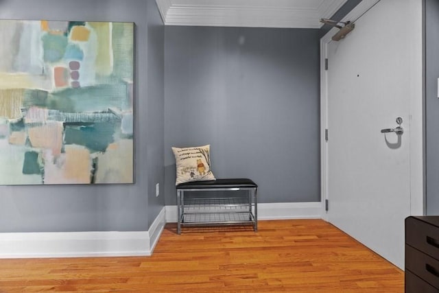hallway with baseboards, ornamental molding, and wood finished floors