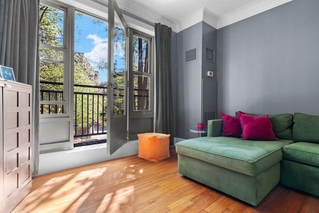 sitting room featuring visible vents, ornamental molding, and wood finished floors