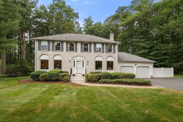 67 Flanagan Dr, Framingham, MA 01701 - colonial home with a chimney, a garage, asphalt driveway, and brick siding