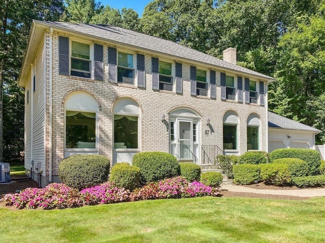 67 Flanagan Dr, Framingham, MA 01701 - view of front of property with a chimney, an attached garage, a front yard, and brick siding