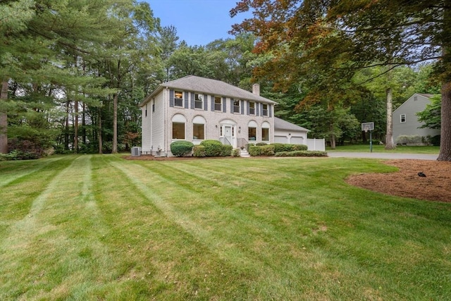 67 Flanagan Dr, Framingham, MA 01701 - colonial home featuring a chimney, a front yard, a garage, and view of scattered trees