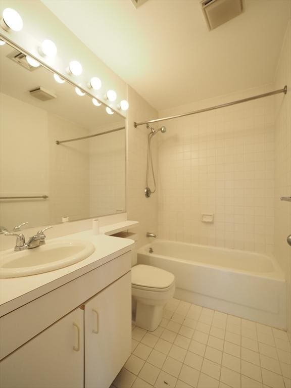 full bathroom with tile patterned floors, vanity, tiled shower / bath, and toilet