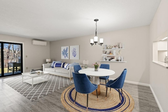 dining room featuring hardwood / wood-style flooring, a chandelier, and an AC wall unit