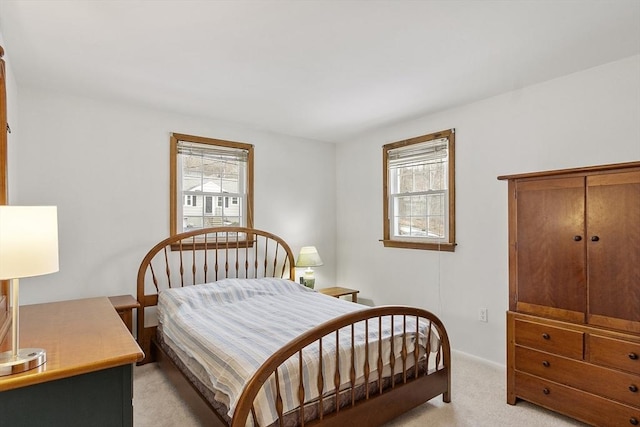 bedroom with multiple windows and light colored carpet