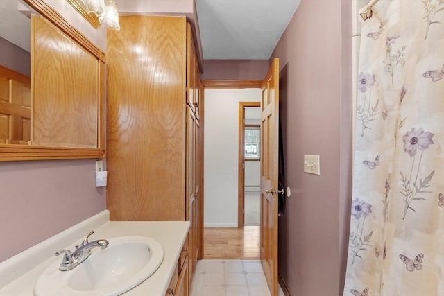 bathroom featuring tile patterned floors, baseboards, and vanity