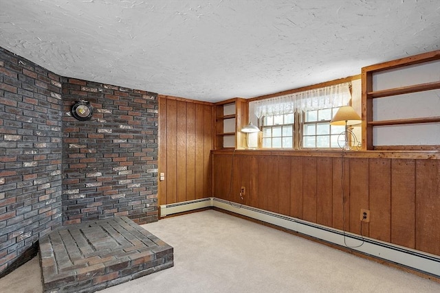 interior space with a textured ceiling, wooden walls, brick wall, baseboard heating, and carpet