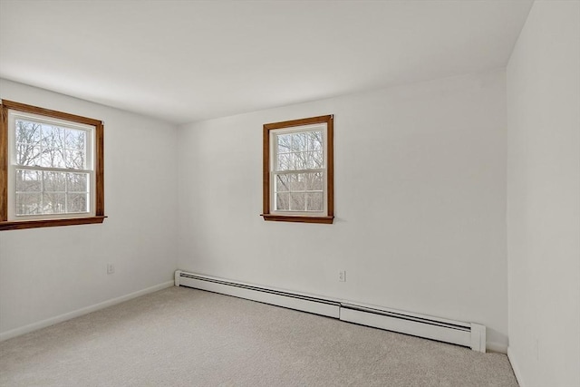 carpeted empty room with baseboards, baseboard heating, and a wealth of natural light