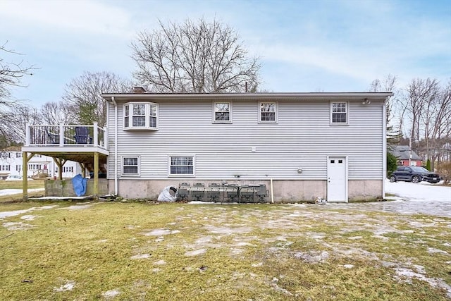 back of property with a deck and a yard