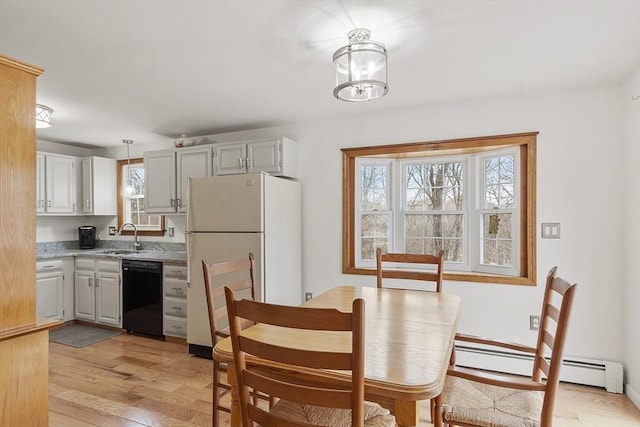 dining space featuring light wood-type flooring and a baseboard radiator