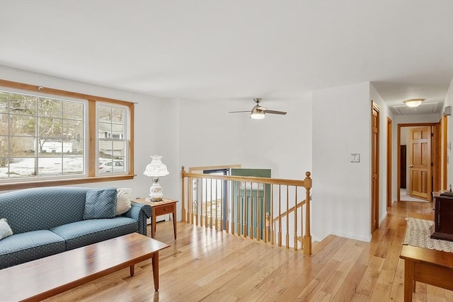 living room with light wood finished floors and a ceiling fan