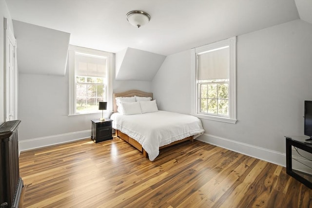185 Woodland St, Natick, MA 01760 - bedroom with vaulted ceiling, multiple windows, hardwood / wood-style flooring, and baseboards