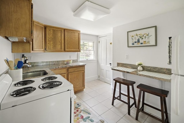 185 Woodland St, Natick, MA 01760 - kitchen with white appliances, a sink, brown cabinets, light tile patterned floors, and light countertops