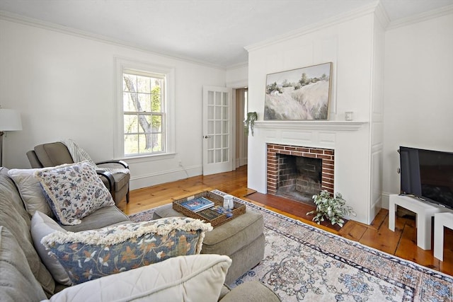 185 Woodland St, Natick, MA 01760 - living area with wood-type flooring, crown molding, a brick fireplace, and baseboards