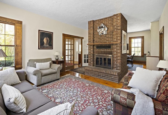 185 Woodland St, Natick, MA 01760 - living room with wood finished floors, a fireplace, and a textured ceiling