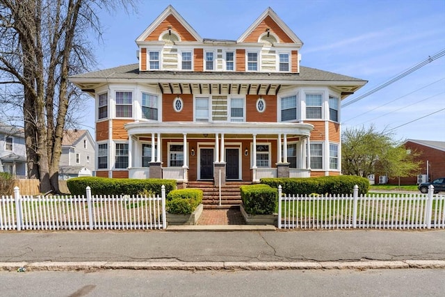 multi unit property featuring a porch and a fenced front yard