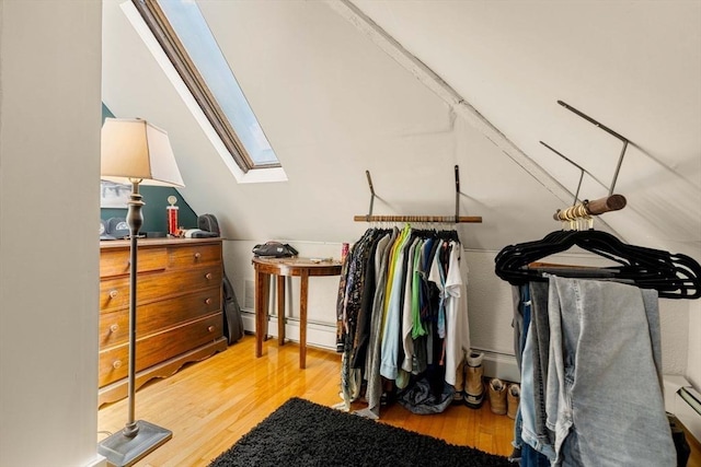 spacious closet with a baseboard radiator, light wood-type flooring, and a skylight