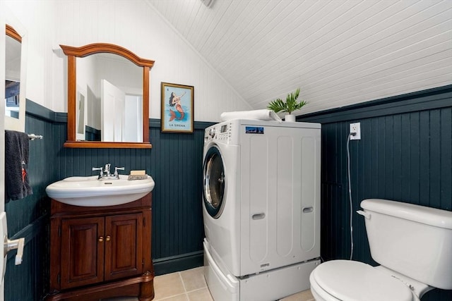 bathroom with a wainscoted wall, toilet, lofted ceiling, and vanity