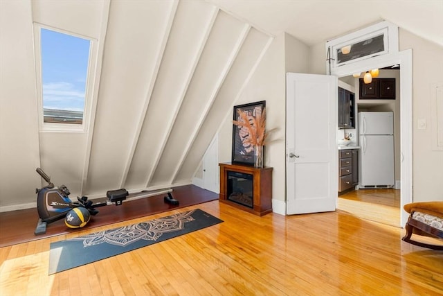 interior space with light wood finished floors and a glass covered fireplace