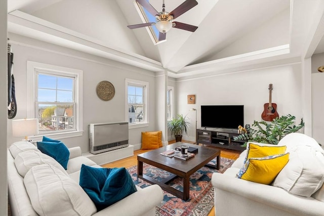 living area featuring a ceiling fan, high vaulted ceiling, plenty of natural light, and wood finished floors
