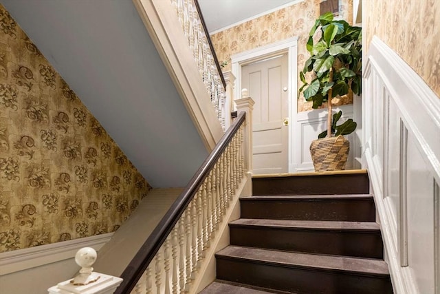 stairway featuring wainscoting and wallpapered walls