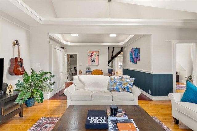 living area with a raised ceiling and wood finished floors