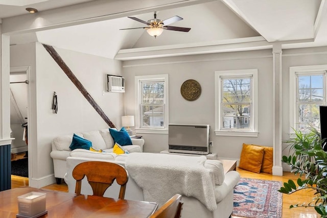 living room featuring wood finished floors, vaulted ceiling, ceiling fan, an AC wall unit, and baseboards