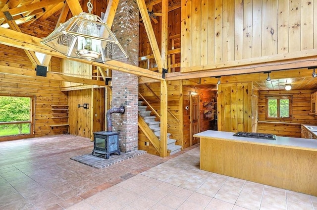 1175 Main Rd, Westport, MA 02790 - kitchen featuring wood walls, high vaulted ceiling, a wood stove, gas cooktop, and beamed ceiling
