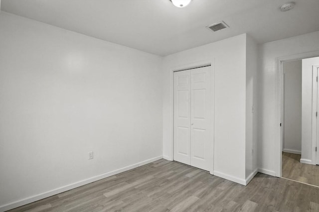 unfurnished bedroom with a closet and light wood-type flooring