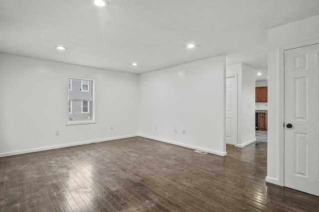 unfurnished room with dark hardwood / wood-style flooring