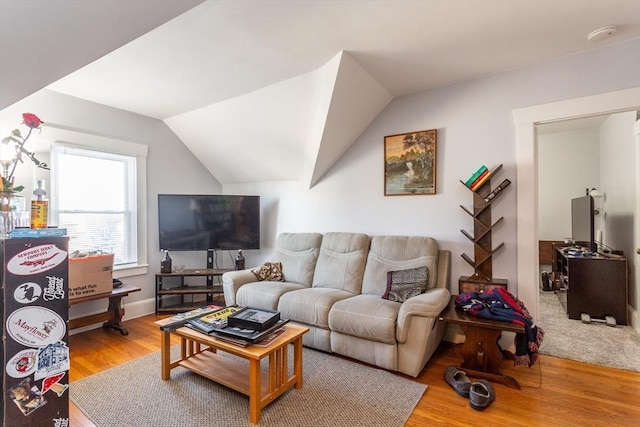 living room featuring lofted ceiling and light wood-type flooring