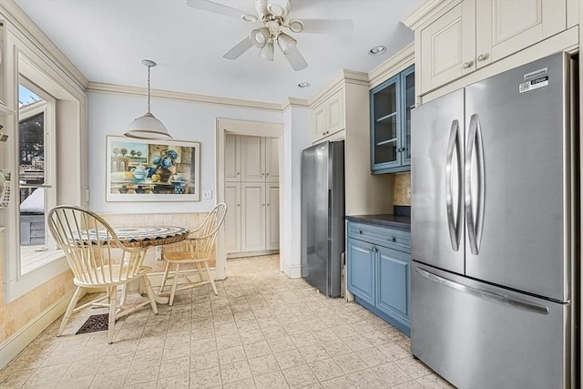 kitchen featuring glass insert cabinets, freestanding refrigerator, dark countertops, and a ceiling fan