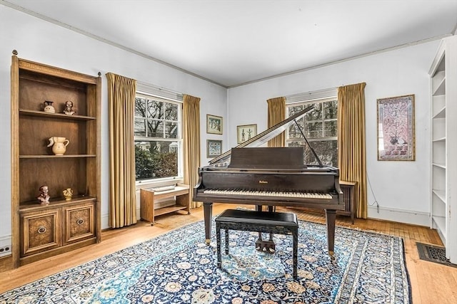 sitting room featuring crown molding, visible vents, a wealth of natural light, and wood finished floors