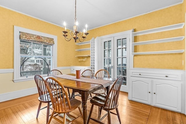 dining room with baseboards, ornamental molding, an inviting chandelier, and light wood-style floors