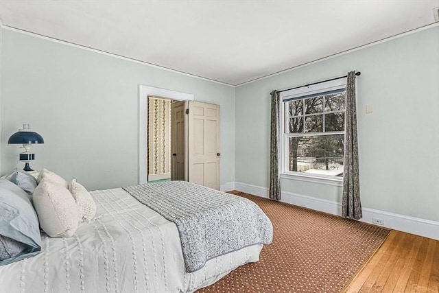 bedroom with baseboards and wood finished floors