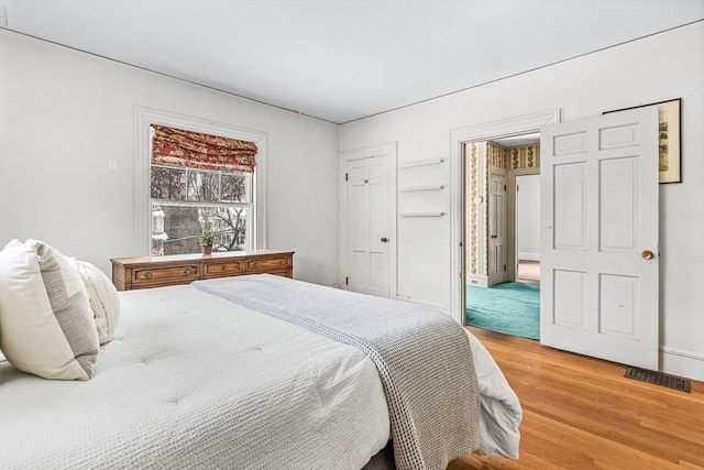 bedroom featuring light wood-type flooring and visible vents