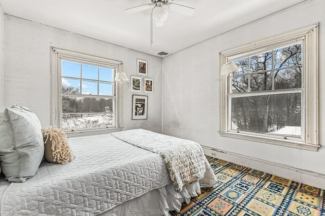 bedroom featuring ceiling fan, multiple windows, visible vents, and baseboards